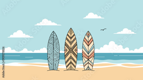Three decorative surfboards with different geometric patterns standing on a sandy beach with the blue ocean and clouds in the background.