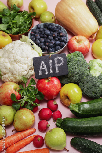 Flat lay of fresh AIP friendly fruits and vegetables on pink