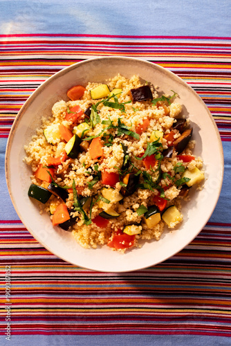 Moroccan vegetable couscous served on a colorful striped tablecloth