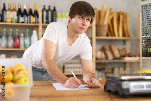 Schilderij op canvas Store manager draws up documents for the purchase of food and groceries for the supermarket