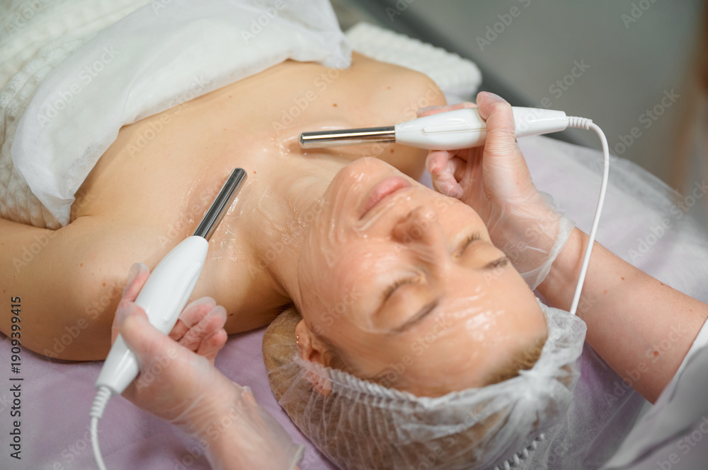 Naklejka premium Woman receiving facial treatment at spa