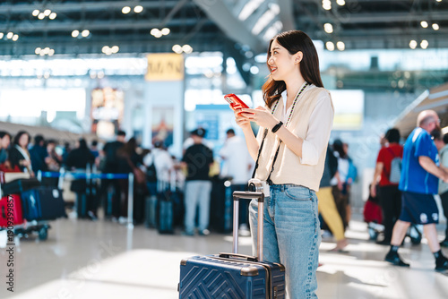 Portrait beautiful adult asian woman using smartphone buying travel insurance claim protect at airport terminal transport