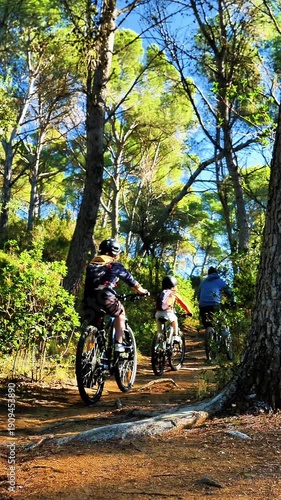 family riding in mountain bike in a forest, father and children