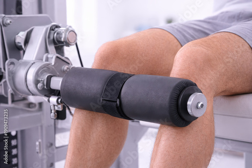 Physical therapy rehabilitation recuperatio leg exercise machine knee extension patient workout support clinic treatment recovery session focused training detail