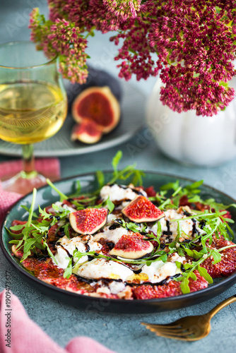 Delicious fresh fig carpaccio with burrata or stracciatella or mozzarella cheese and arugula salad