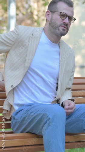 Modern Casual Man Sitting Outdoor with Back Pain, Vertical Video