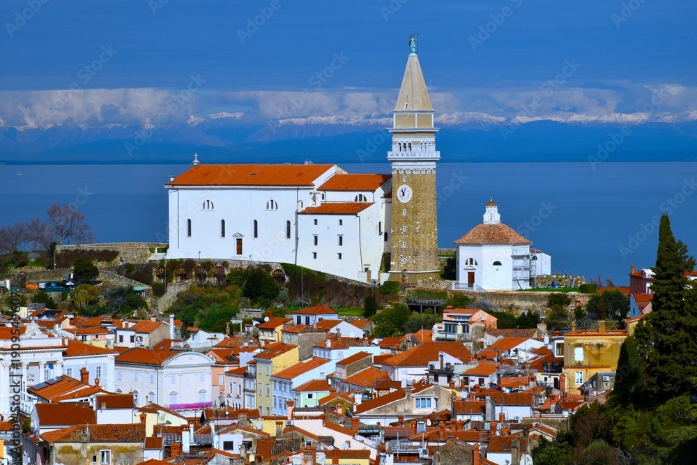 Fototapeta premium St. George's parish church above the town of Piran at the Adriatic sea in Istria, Primorska, Slovenia and the alps in the distance