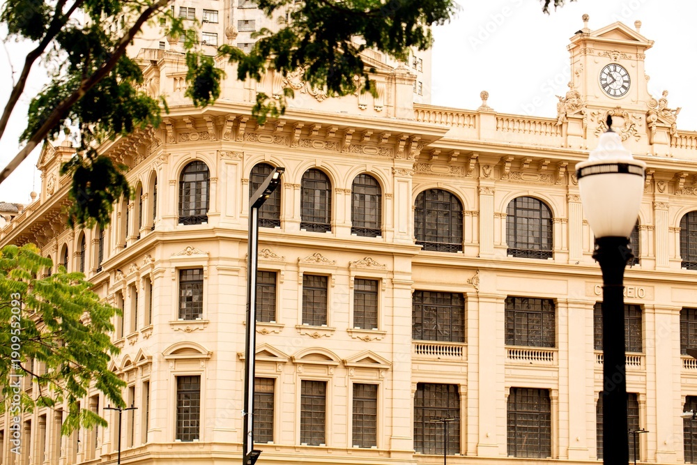 Fototapeta premium Fachada de prédio com janelas em forma de arco e poste de rua. 