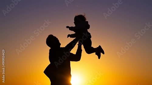 Father Lifting Child at Sunset Silhouette.
