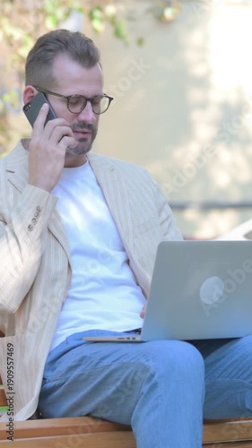 Modern Casual Man Working on Laptop and Smartphone, Vertical Video