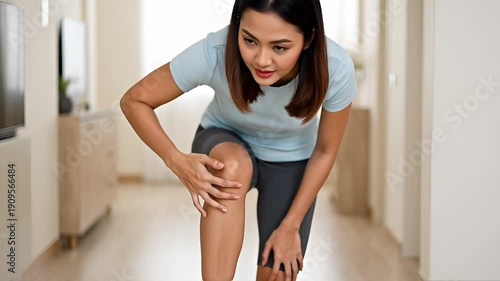 Woman experiencing knee pain indoors.