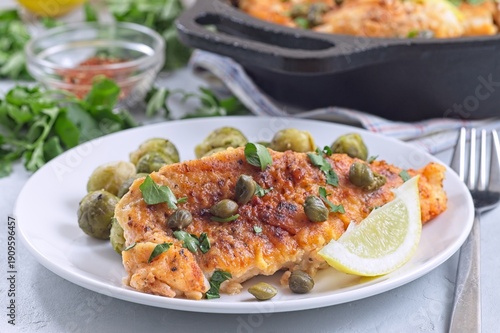 Delicious pan seared fish with capers, brussels sprouts, and lemon, horizontal