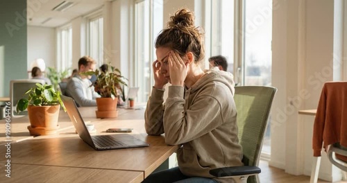 Woman working at desk with laptop in modern office environment