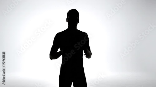 Wallpaper Mural A silhouetted, muscular man gestures towards bright light Torontodigital.ca