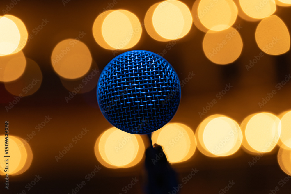 Fototapeta premium Professional Vocal Microphone with Blue Lighting on Warm Golden Bokeh Background