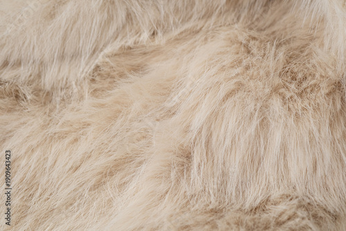 Textured natural beige faux fur material offering a soft fluffy cozy luxurious detailed surface