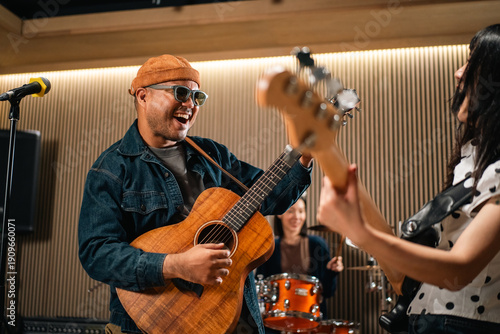 Konstfotografi Young asian music group Band members rehearse with instruments guitar bass drum