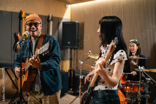 Bild auf Leinwand Young asian music group Band members rehearse with instruments guitar bass drum