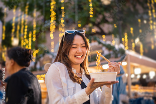 Photography Asian woman enjoy eating street food at night market