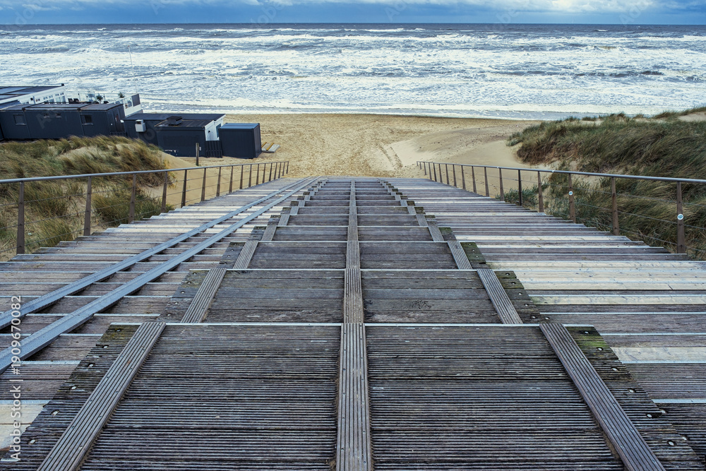 Fototapeta premium Steps down to Egmond aan Zee beach during a choppy North Sea.