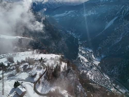 Wallpaper Mural clouds coming in Chamois alpine village aerial view in winter season Torontodigital.ca