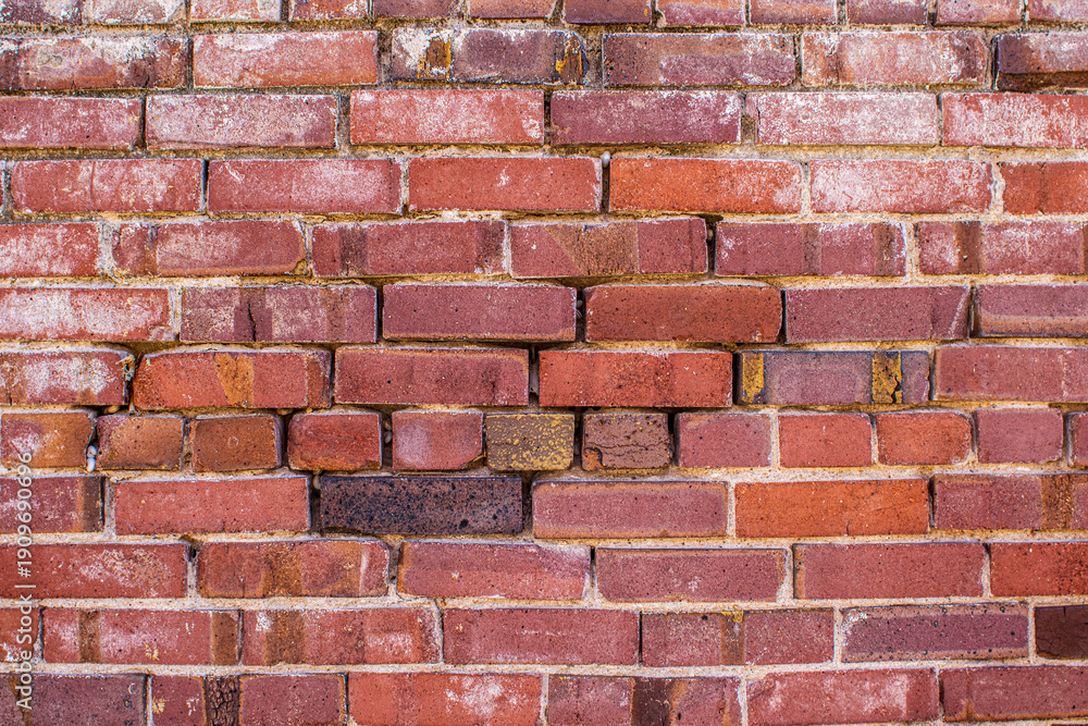 Fototapeta premium Brick wall with faded paint makes for unique texture
