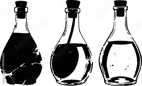 Set of three transparent glass bottles with cork stoppers filled with different liquids isolated on white