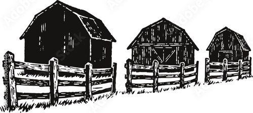 three rustic wooden barns with fenced enclosures in countryside rural landscape