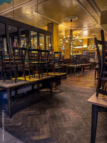 View of empty bar early in the morning with chairs upturned .