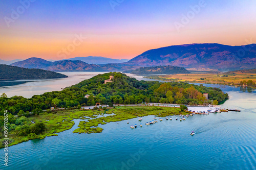 Butrint National Park with Venetian castle, lagoon and Bufi river with ferry crossing, Butrint, Albania at sunset.
