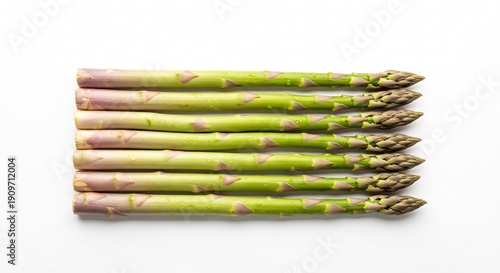 Fresh green asparagus spears stacked on white surface