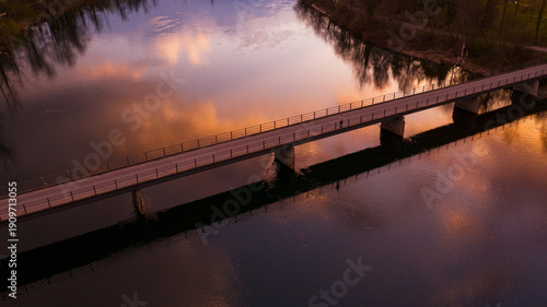 Wallpaper Mural Aerial view of a person standing on a bridge over the Aare river at sunset with vibrant orange cloud reflections, Aarau, Switzerland Torontodigital.ca