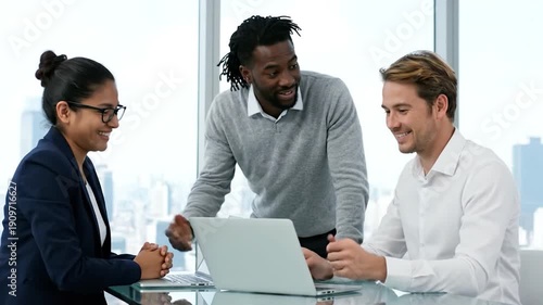 Three professionals in an office setting discussing, with a laptop present