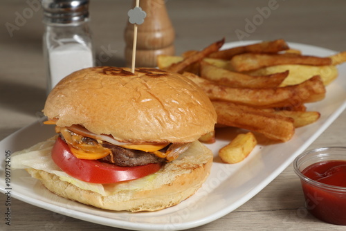 Un hamburger avec des frites sur une assiette