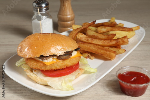 Hamburger avec frites sur une assiette blanche
