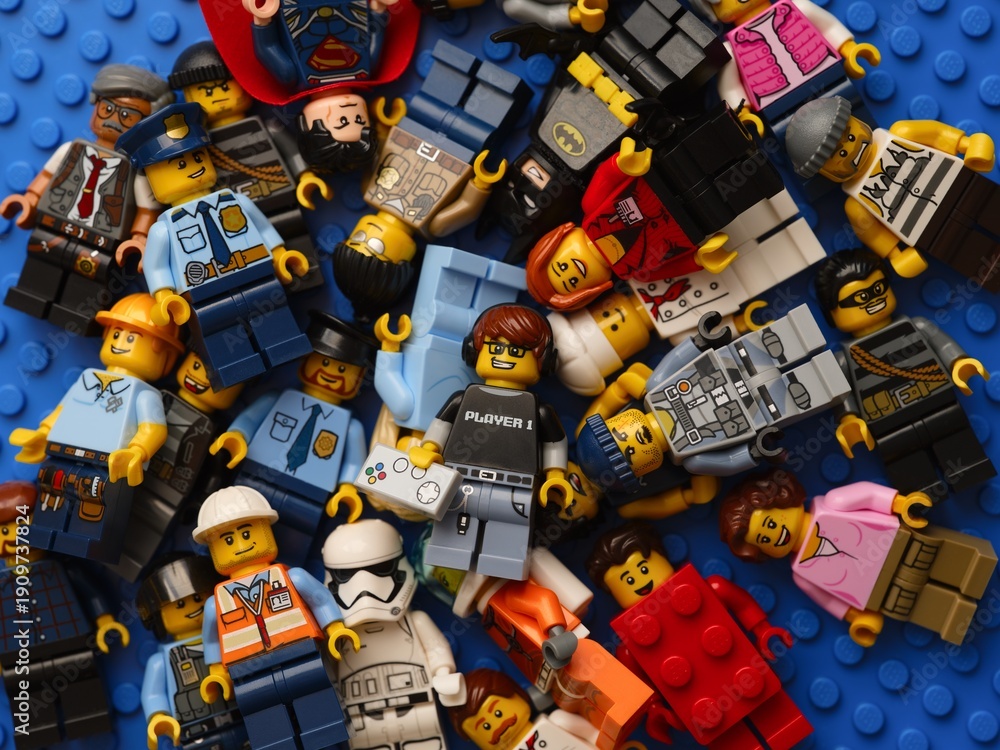 Obraz premium Tambov, Russian Federation - February 02, 2026 Pile of Lego minifigures on blue baseplate background