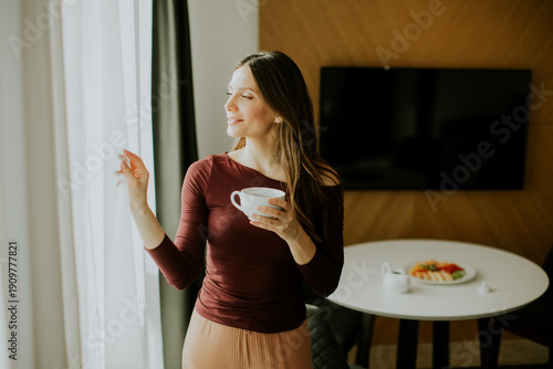 Woman enjoys coffee while l...
