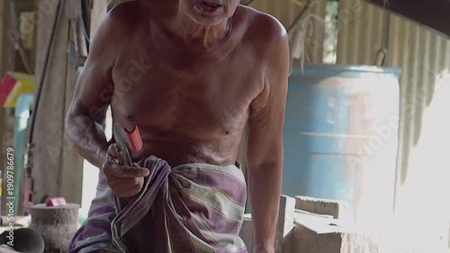 Old man rubber tapper shirtless worker rural traditional knife manual labor elderly man village workshop rubber tapping craft Asian rural life