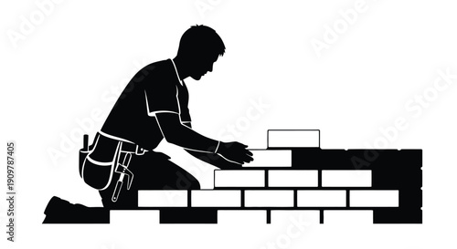 Silhouetted mason kneeling and laying bricks in a wall construction