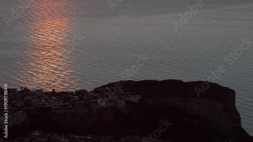 Golden sunset over rocky Mediterranean coastal peninsula