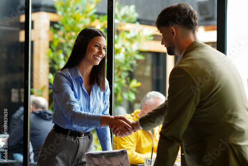 Bilde på lerret Meeting takes place in a cafe with two people shaking hands over a business deal