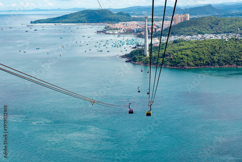 Sunset town, Phu Quoc, Vietnam. Aerial view of An Thoi harbor with coastal fishermen village, fishing boats, turquoise sea and modern cable car ride. Modern Hon Thom cable car cabin
