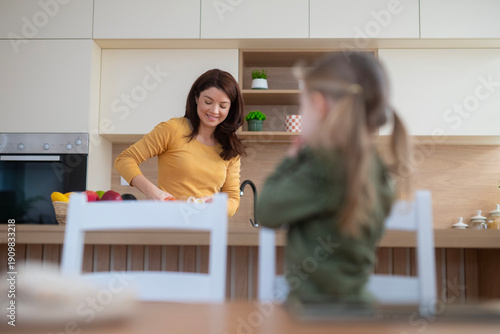 Mother and daughter spending morning time in modern kitchen