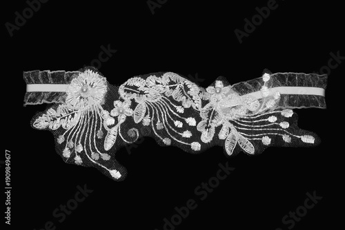Women's lace wedding garter on a black background.