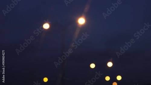 3 Clips: Night lights in the city. Road lights shining through the dirty window of a car driving on the highway. Ideal for music videos. Psychedelic atmosphere, glowing lights, a melancholic journey.