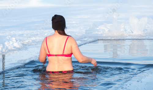 The woman in the back makes a polar plunge into a frozen lake at sunset. Cold Water Immersion for Health and Resilience