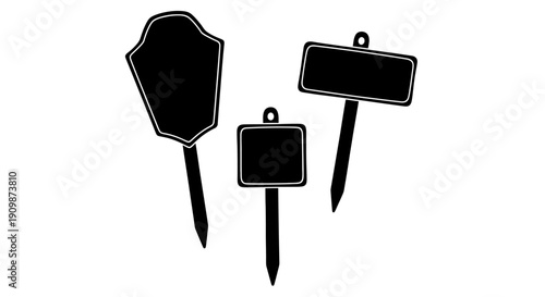 Collection of black signboards with various shapes on stakes, standing upright on a white background, viewed from the front