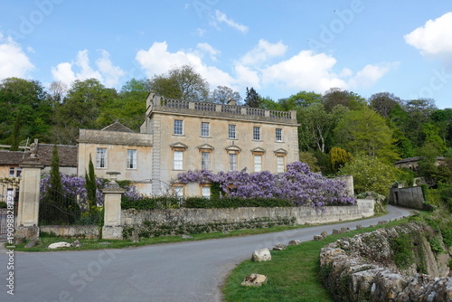 View of a beautiful old mansion house on a country road in a tranquil English village
