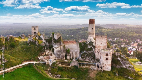 Castle ruins in Olsztyn near Częstochowa captured in golden hour light, aerial drone view over limestone rocks and historic fortress in Poland