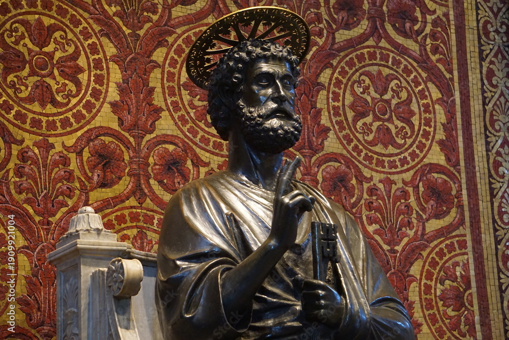 Fototapeta premium Side profile close up portrait of the iconic bronze statue of Saint Peter inside St. Peter's Basilica in the Vatican, Rome, Italy, sitting on a throne with a halo, holding a key